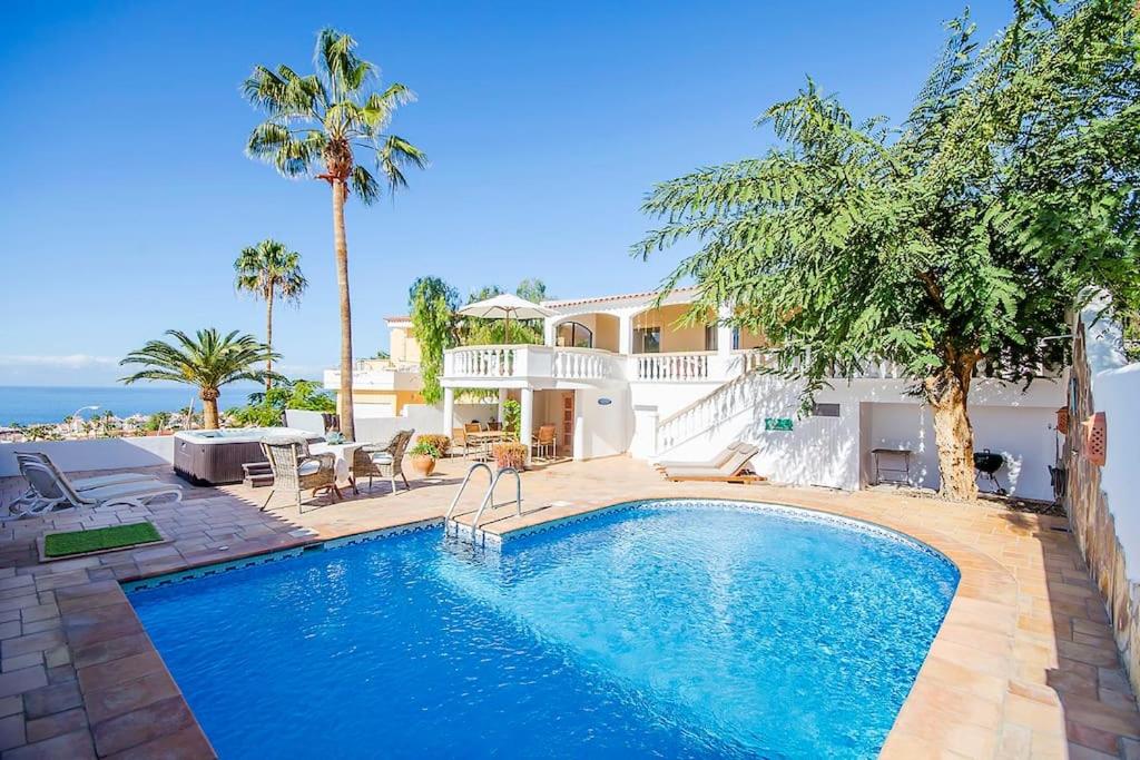 a swimming pool in front of a house at Villa with Private Pool, Jacuzzi & 360° Sea Views in Callao Salvaje
