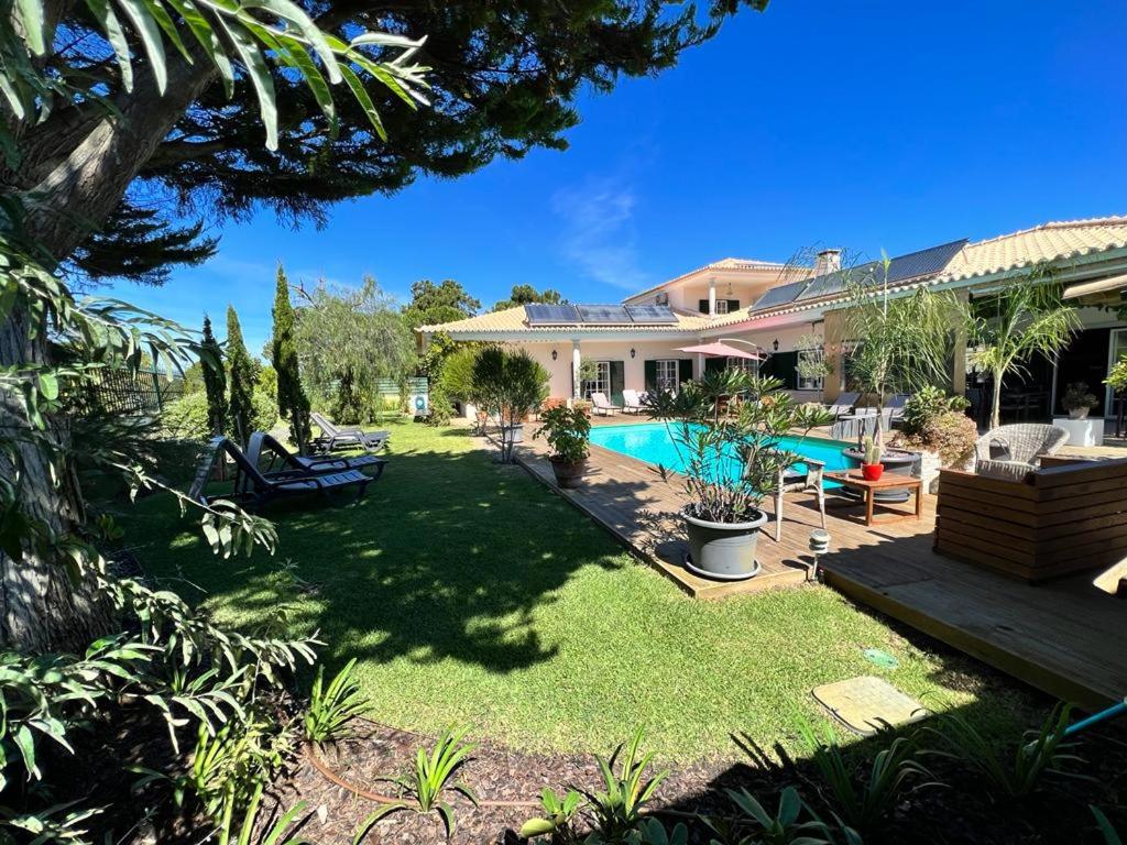 a house with a yard with a swimming pool at Buganvilias Do Meco Guest house in Sesimbra
