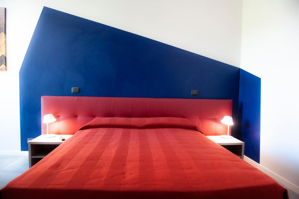 a bedroom with a red bed with a blue wall at B&B Lough in Colà di Lazise