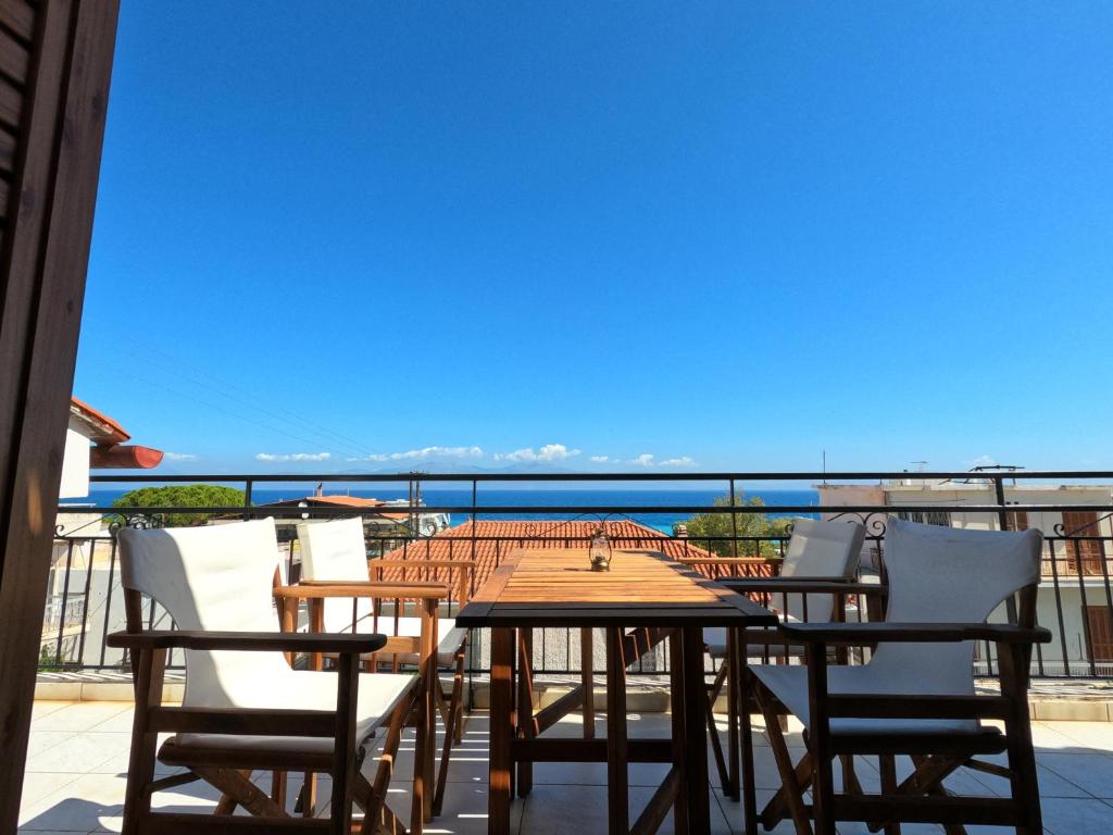 a table and chairs on a balcony with a view of the ocean at Loft apartment 20m from sea in Melission