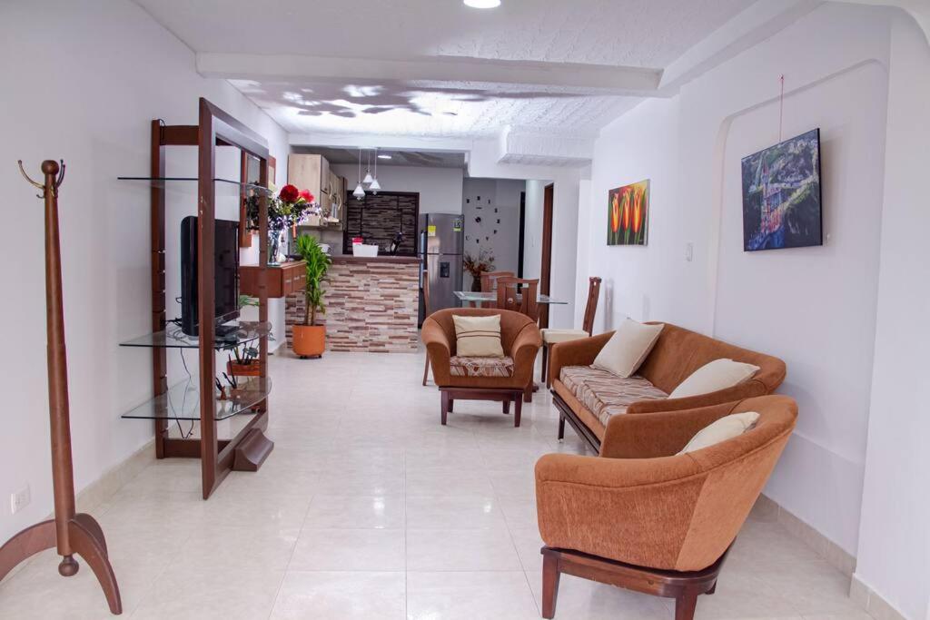 a living room with two couches and a tv at Apartamento confortable, cerca a la Basílica in Buga