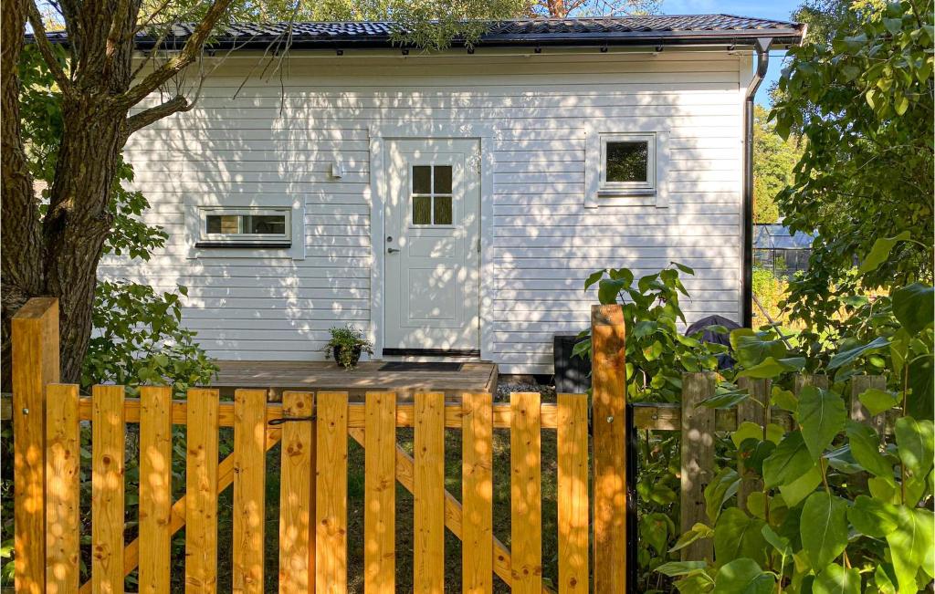 a white house with a wooden fence in front of it at Beautiful Home In Gotlands Tofta With Kitchen in Gnisvärd