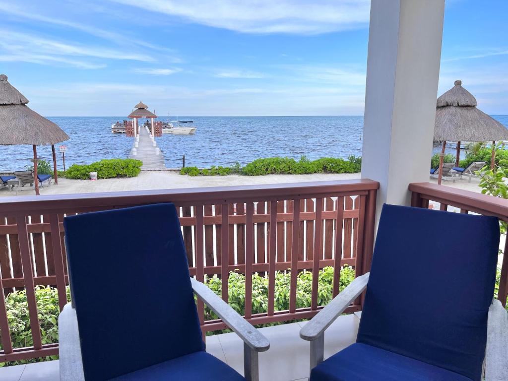 two chairs on a balcony looking out at the ocean at VeLento Oceanfront #4 in Caye Caulker
