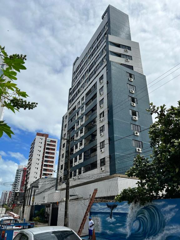 a tall building with a person standing in front of it at Puerto de Villas in Recife