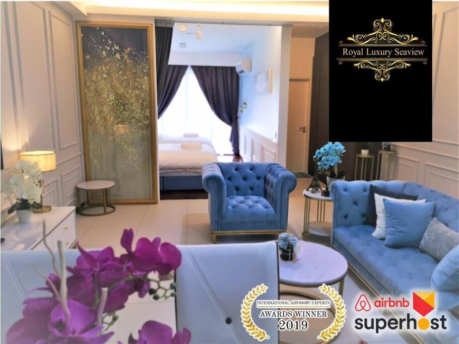 uma sala de estar com dois sofás azuis e uma cama em 皇家海景ROYAL Luxury Seaview Room, 3 minute to Gurney em Tanjong Tokong
