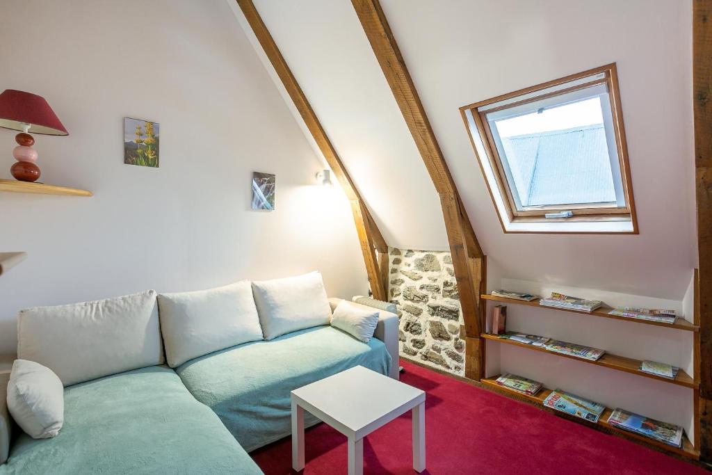 a living room with a couch and a window at Gite Les Marmottes in Trémouille