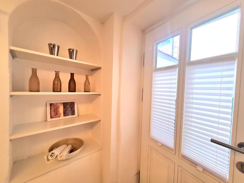 a bathroom with a window and shelves and a door at Townhouse 1 Deidesheim in Deidesheim