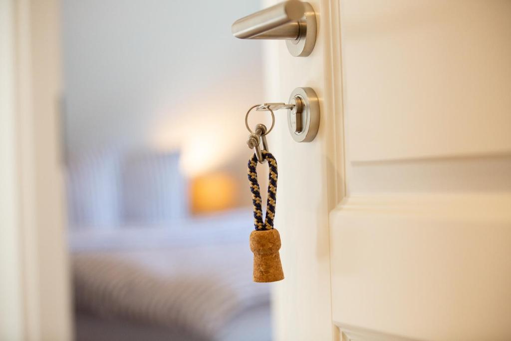 a door knob with a dog tag on it at Letj Dünem Hüs in Norddorf