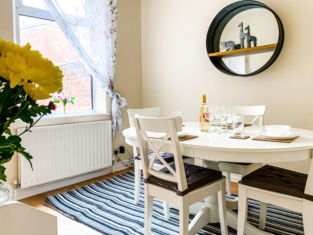 a white dining room table with chairs and a mirror at The Warwick - Quaint Victorian Home With Free Parking in York