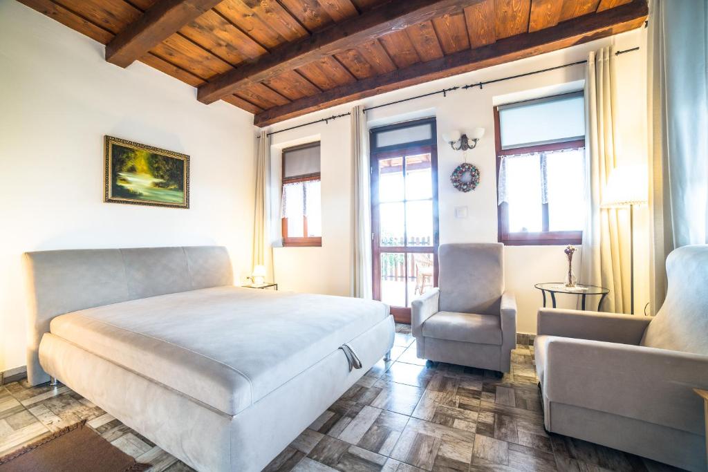 1 dormitorio con 1 cama, 1 silla y ventanas en Hegyaljai Panoráma Vendégház, en Szerencs