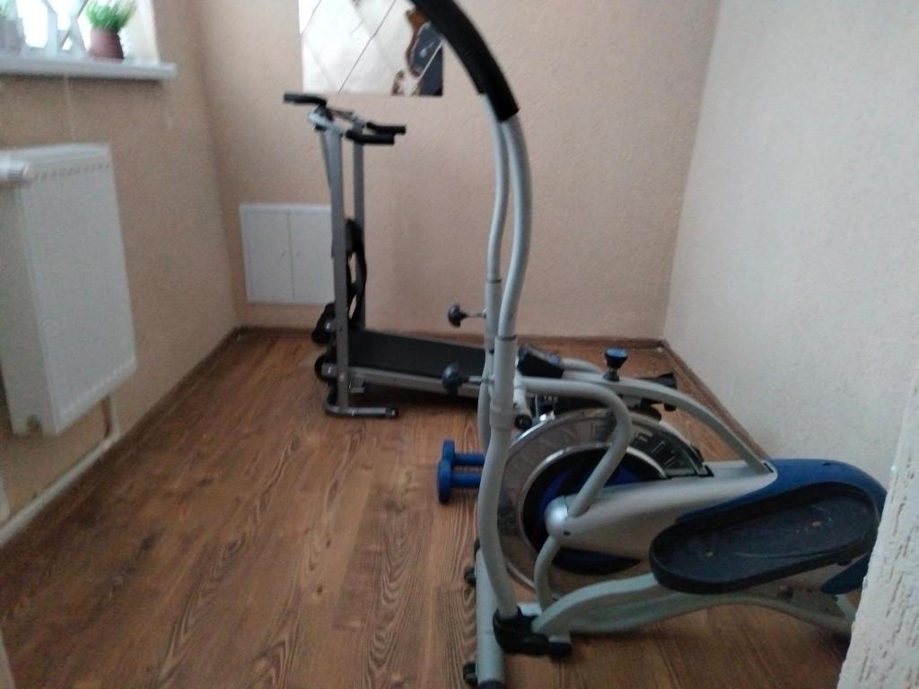 a exercise bike in a room with a wooden floor at Apartament Geo in Nehoiu