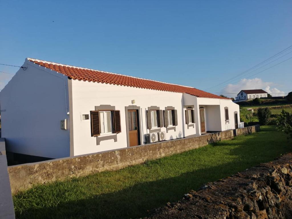 ein weißes Haus mit einer Wand in der Unterkunft Casa do Lajedo in Porto Martins