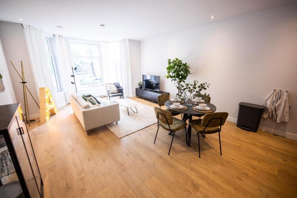 een woonkamer met een tafel en stoelen bij Quality 2 Bedroom Serviced Apartment 72m2 -VP2A- in Rotterdam