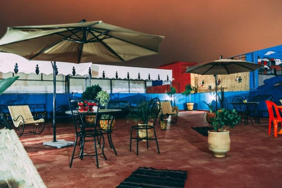 un patio con tavoli, sedie e ombrelloni di Dar Rita a Rabat