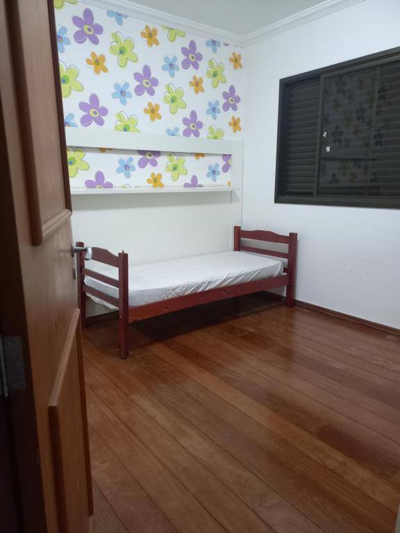 une chambre avec un banc orné de fleurs sur le mur dans l'établissement Apt na região central , Completo com 2 camas casal, à Patos de Minas