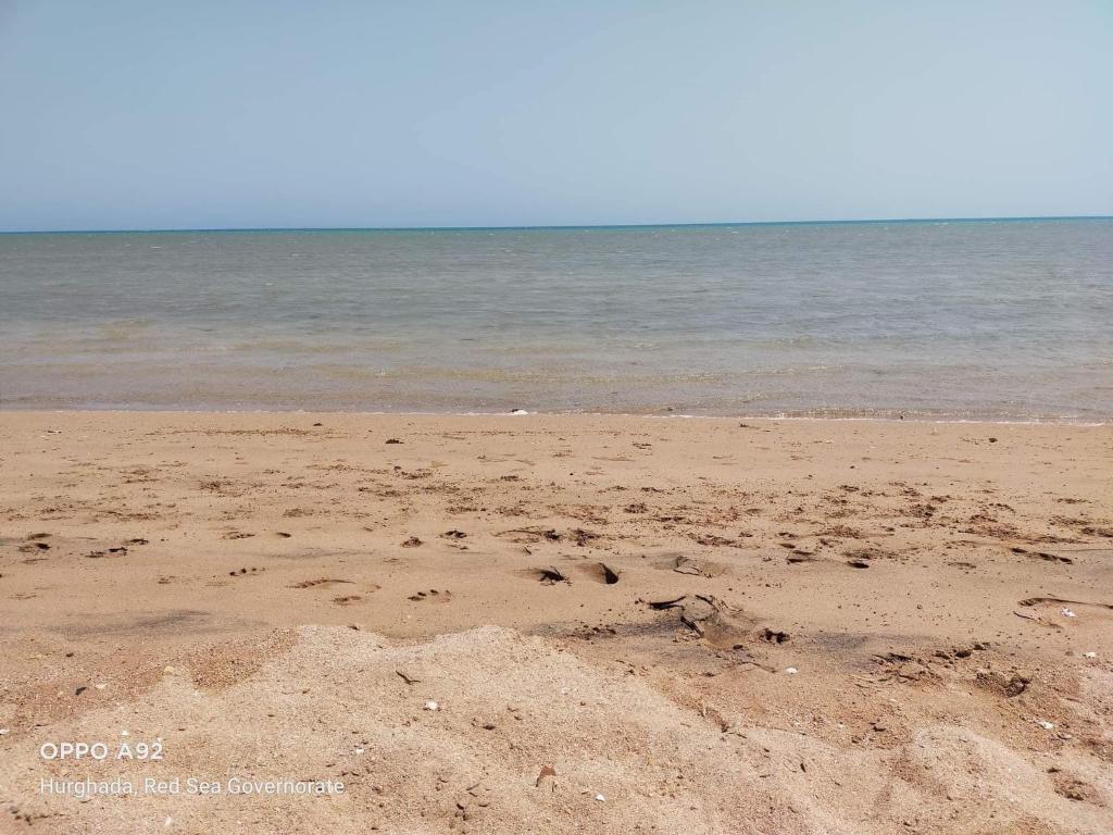 einen Sandstrand mit dem Ozean im Hintergrund in der Unterkunft Apartment Place of Dreams near the sea RedSeaLine in Hurghada