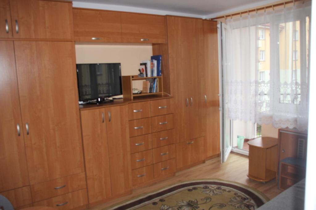 a living room with wooden cabinets and a tv at Mieszkanie u Diany i Piotra in Ustka