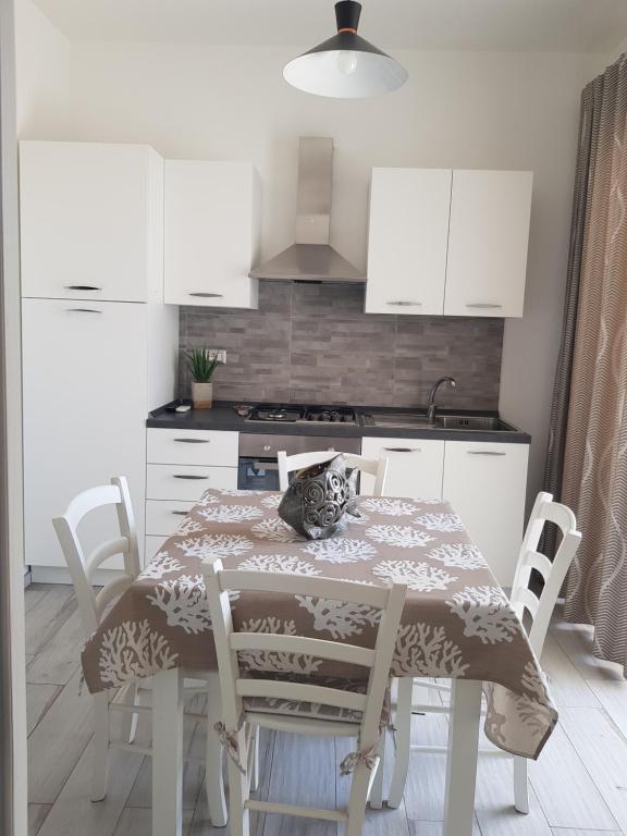 Appartamento nuovo في لامبيدوسا: مطبخ مع طاوله مع قطه جالسه عليه