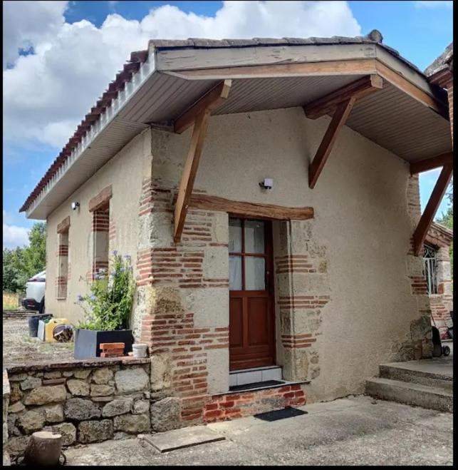 une petite maison en briques avec une porte marron dans l'établissement Auvillar: gîte au calme en pleine nature 2/4pers, à Saint-Loup
