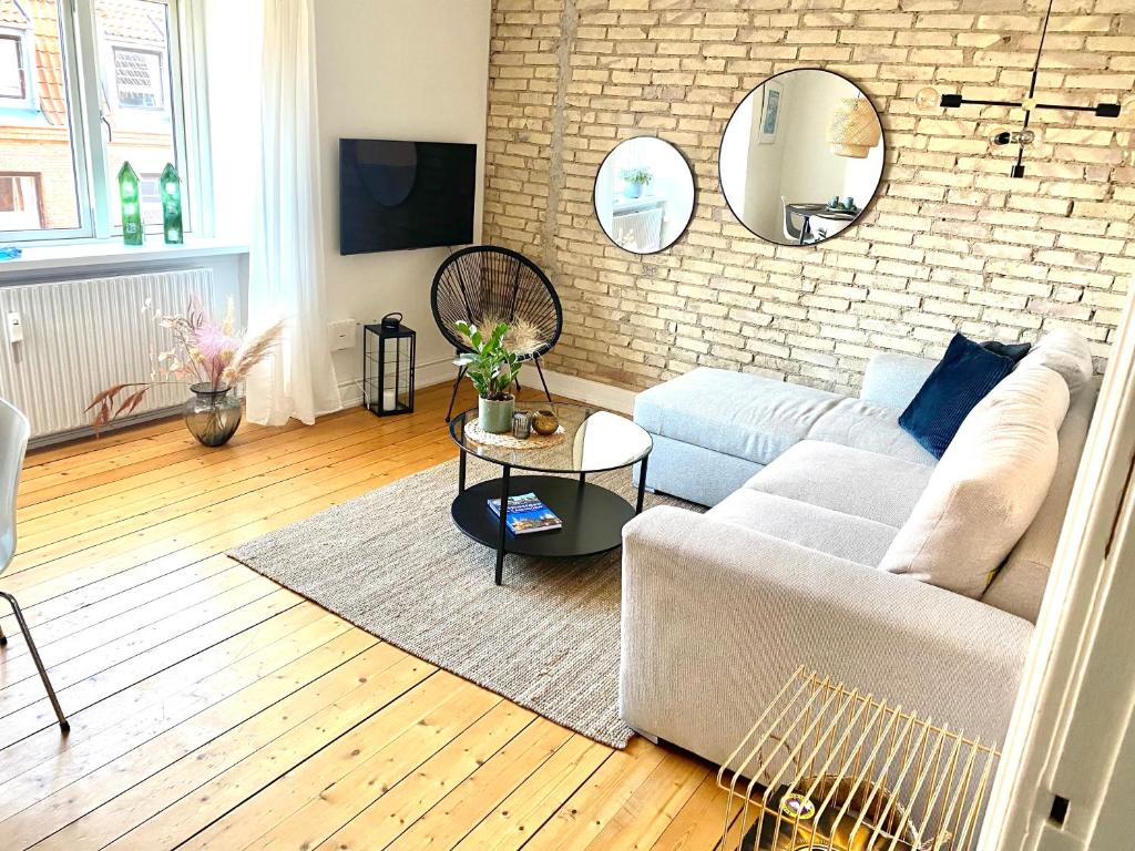 uma sala de estar com um sofá e uma parede de tijolos em Anna em Aalborg