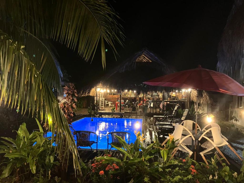 a pool with chairs and an umbrella at night at Kaluta in Palomino