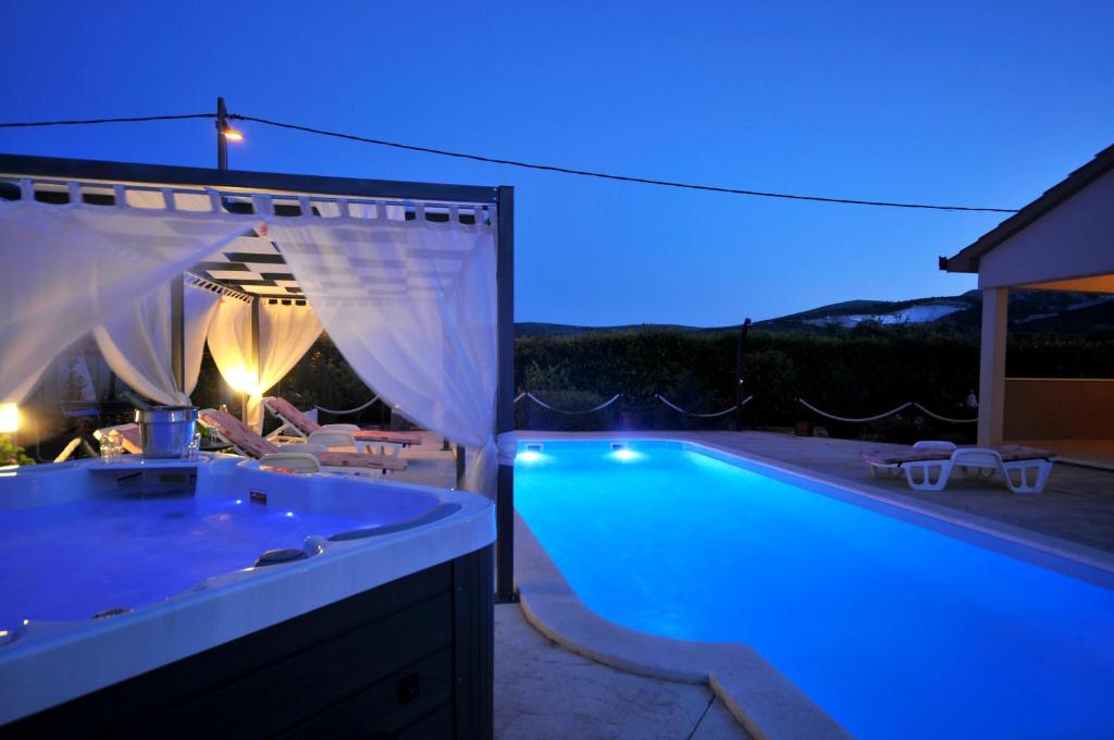 Una piscina en un patio trasero por la noche. en Beautiful Holiday Home "Villa Luka", en Kaštel Štafilić