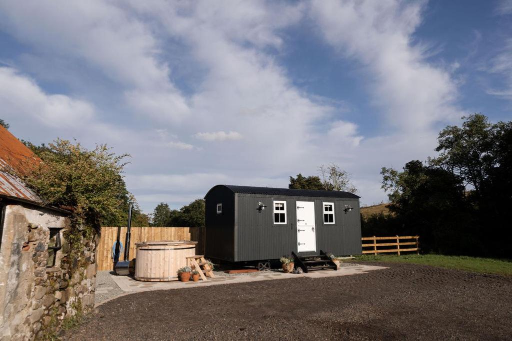 a tiny house sitting on the side of a road at Barfield Shepherds Hut in Magherafelt