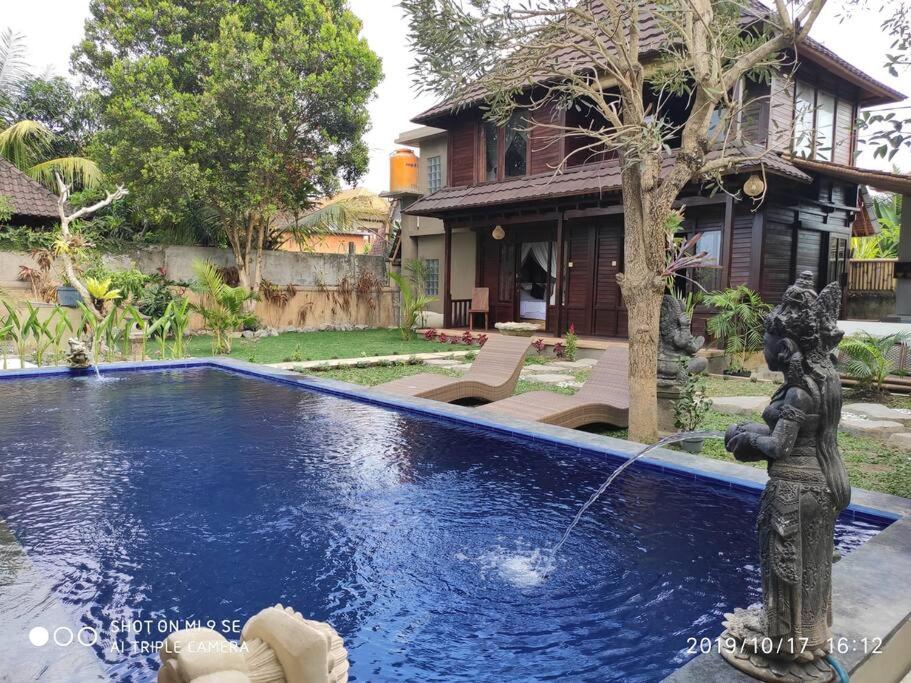 een fontein voor een huis met een huis bij TEGESWOODHOUSE A with WiFi,Ac in Ubud