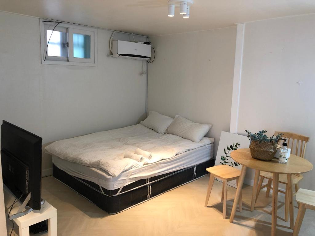 um pequeno quarto com uma cama e uma pequena mesa em Rich House Dongdaemun em Seul