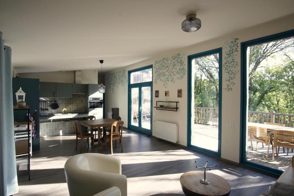 a kitchen and living room with a table and chairs at Le Nid d'Écureuil in Épiry