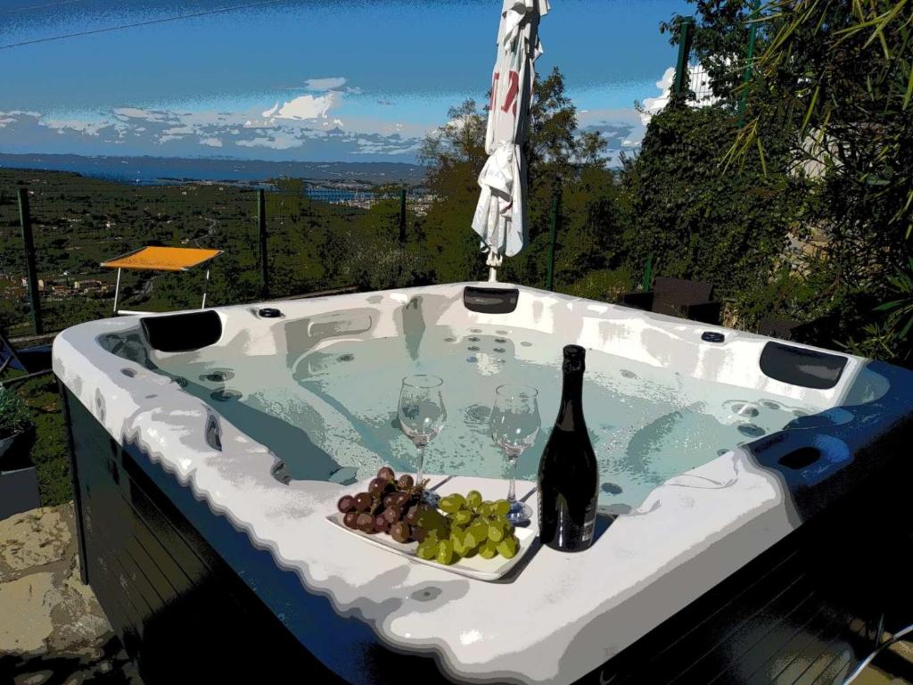 a hot tub with a bottle of wine and wine glasses at Apartma Matjaž in Koper