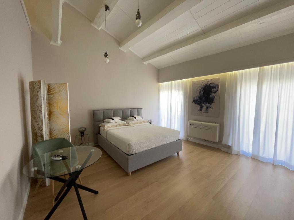 una camera con letto e tavolo in vetro di Off House Borgo Suite, Nettuno a Nettuno