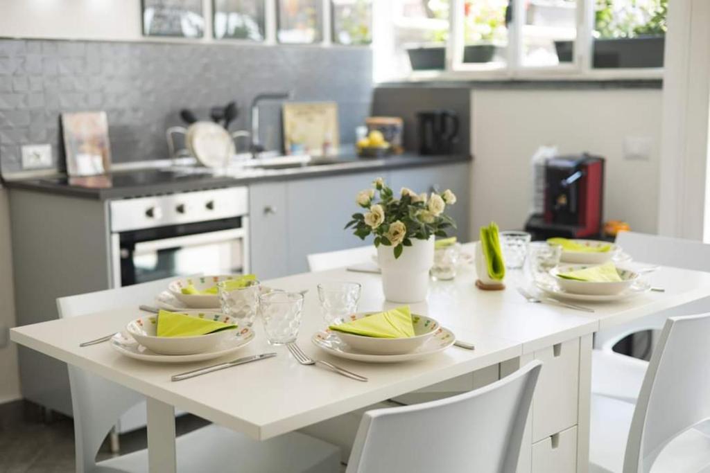 una cocina con una mesa blanca con platos. en A due passi dal Duomo, en Acireale