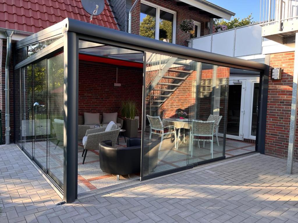 a glass extension of a house with a patio at Fehnland in Großefehn 