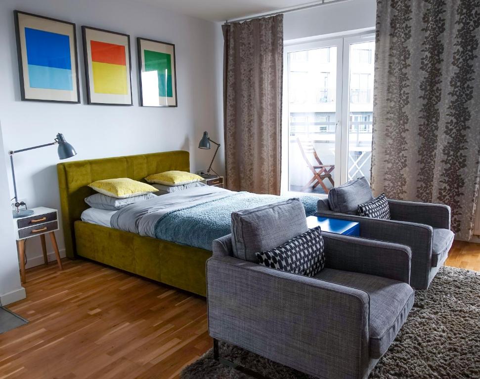 1 dormitorio con 1 cama, 2 sillas y ventana en Arena Studio, en Cracovia