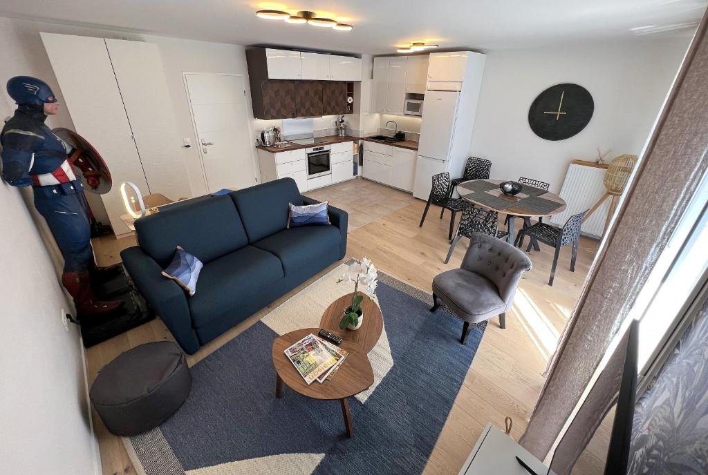 a living room with a blue couch and a kitchen at Appartement 6 pers Val d'Europe - Disneyland Paris - Captain America in Chessy