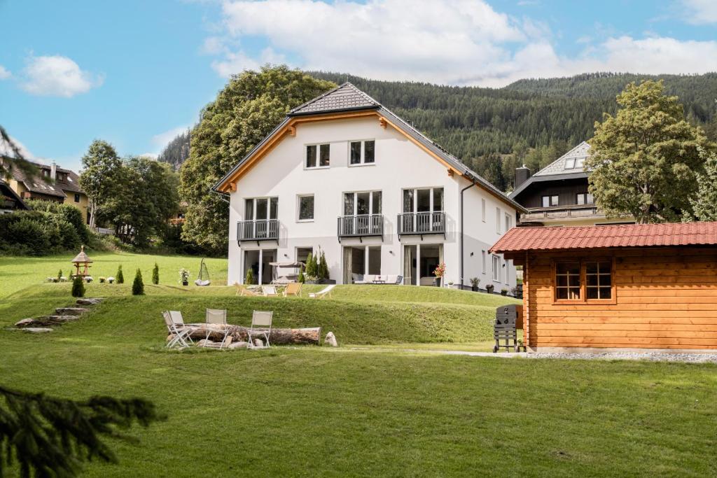 a large white house on a green lawn at Granit Appartements in Mauterndorf