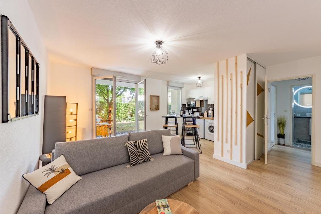 ein Wohnzimmer mit einem Sofa und einer Küche in der Unterkunft To Be Discovered L'escapade Cosy in Pradines