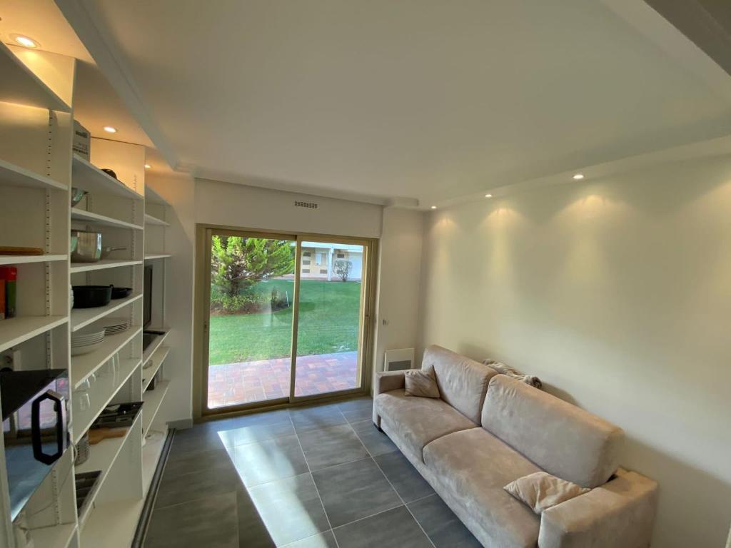 un salon avec un canapé et une grande fenêtre dans l'établissement Studio deauville Situé devant la plage, à Deauville