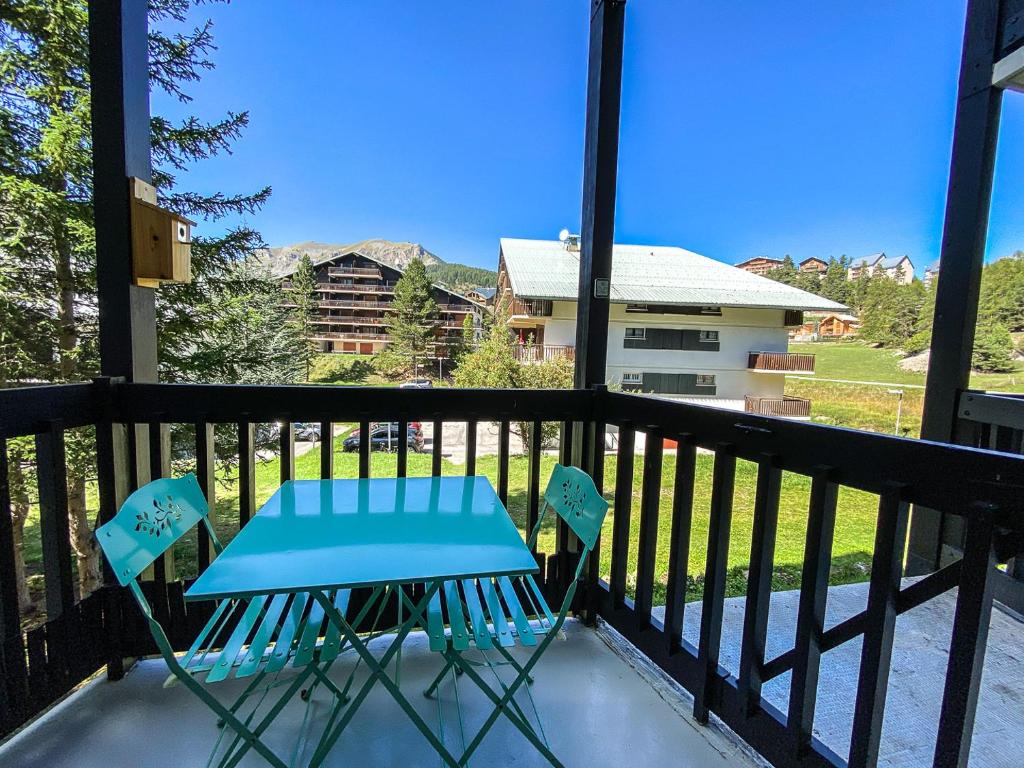 d'une table bleue et de deux chaises sur un balcon. dans l'établissement Studio balcon vue Alpes pistes de ski à 5 min, à Saint-Étienne-de-Tinée