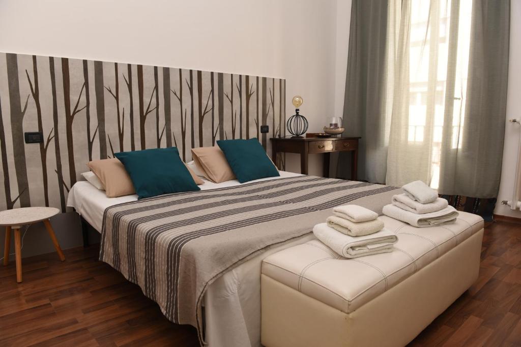 een slaapkamer met een groot bed en handdoeken bij La Casetta di Vale in Taranto