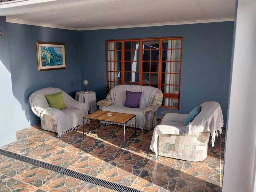 a living room with two chairs and a table at GUINEA FOWL in Plettenberg Bay