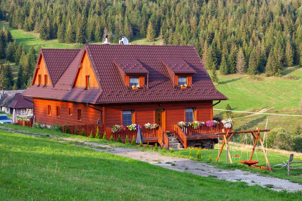 una gran casa de madera en medio de un campo en Privat Bachledova dolina, en Ždiar