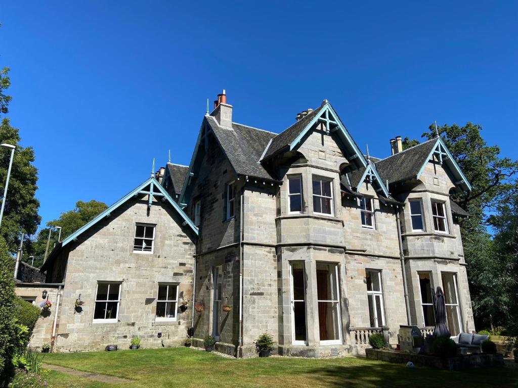 Auchendinny的住宿－Fabulous 2 Bedroom House just outside Edinburgh，一座蓝色天空的古老石头房子