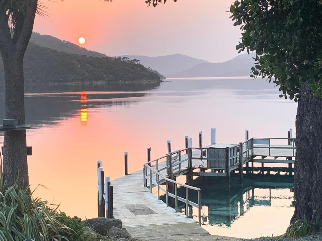 a dock on a body of water with a sunset at Resolution Bay in Resolution Bay