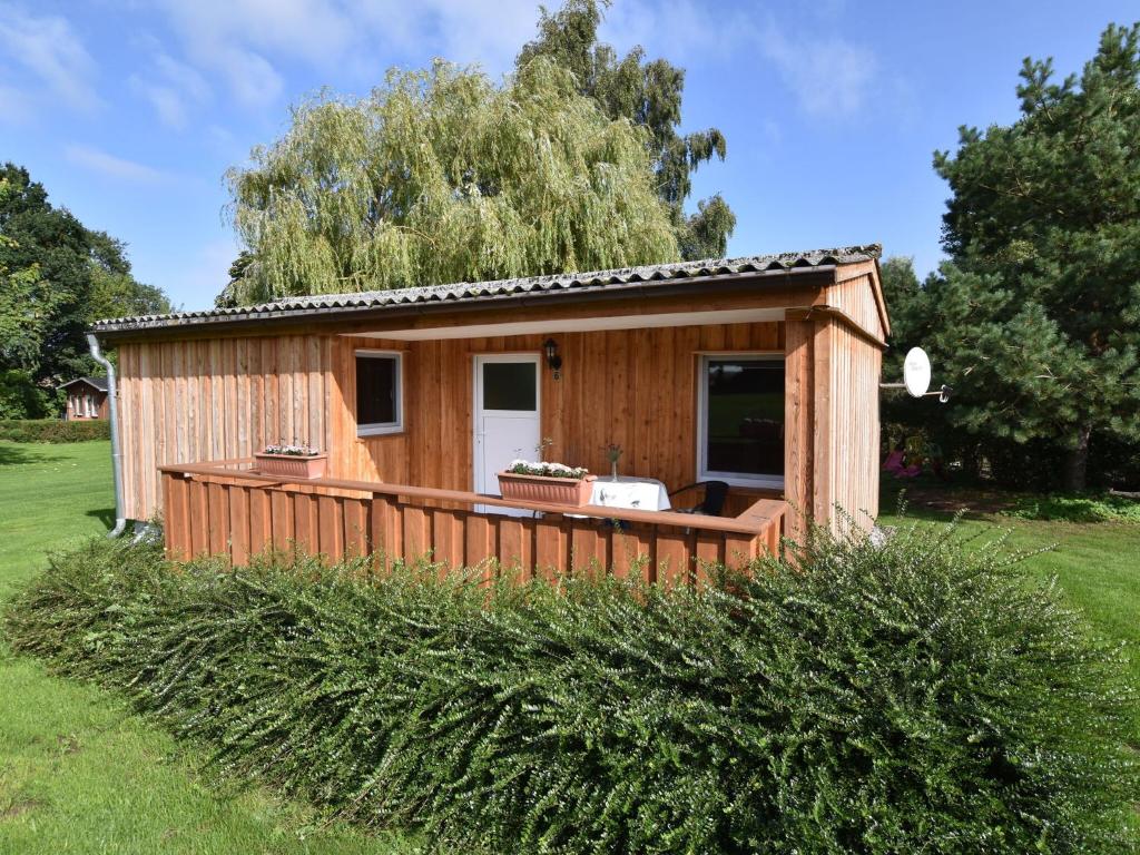 a tiny house with a deck in a yard at Insel- Bungalow auf Poel in Insel Poel