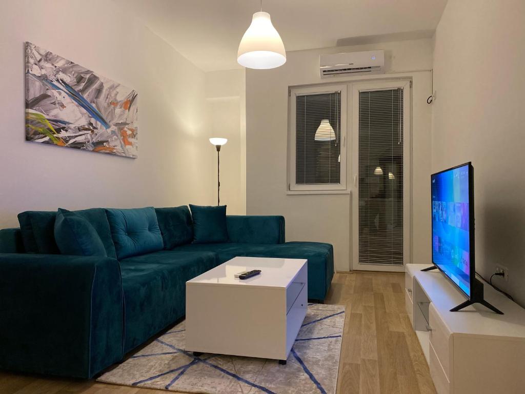 a living room with a blue couch and a tv at Old Bazaar Apartment with Private Parking in Skopje