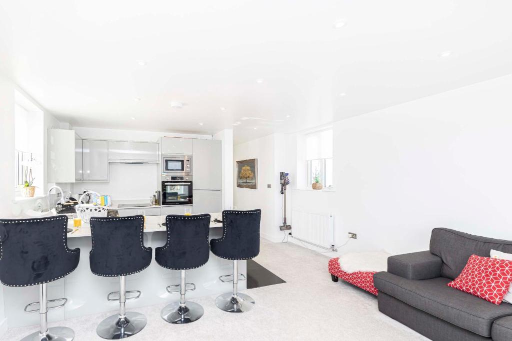 a living room with a couch and a kitchen at The White House - Lux Southbourne beach 3 bed stay in Southbourne