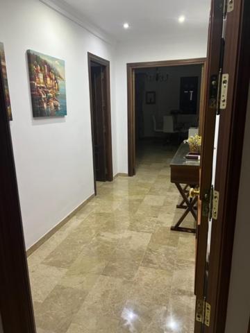 un pasillo con una puerta que da a una habitación con una mesa en Alojamiento las Delicias, en Hornachuelos