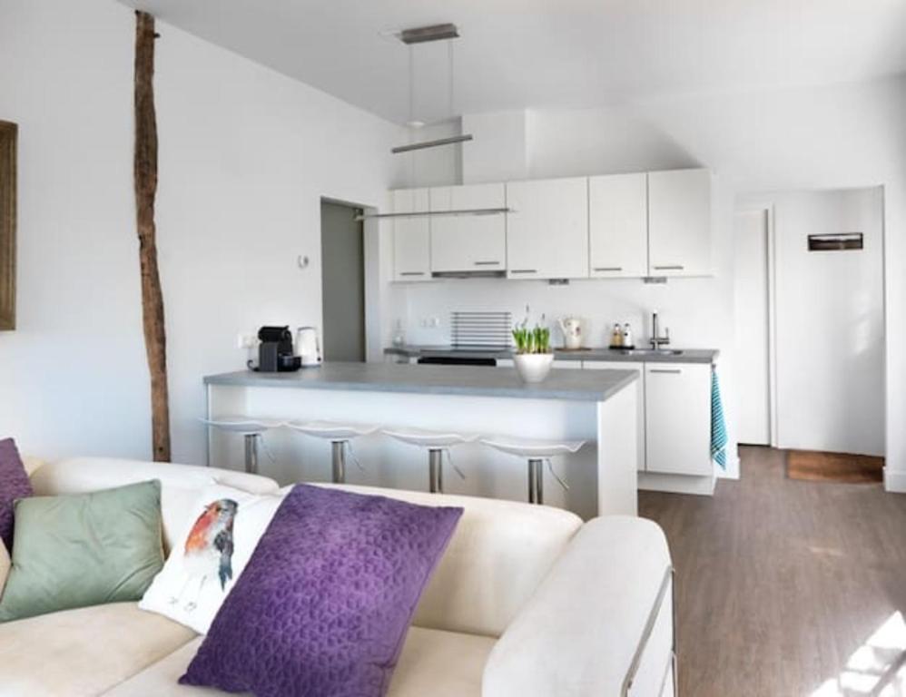 a living room with a couch and a kitchen at Het Appense veld in Klarenbeek